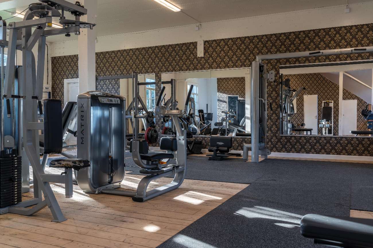 Gym med styrketräningsmaskiner och spegelvägg