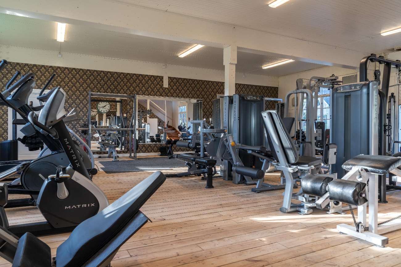 Gym med konditionsmaskiner och trägolv
