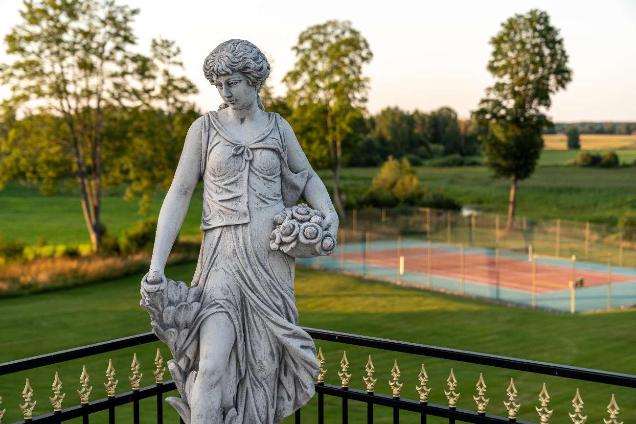 Staty på terrassen med utsikt över tennisbanan och ängarna