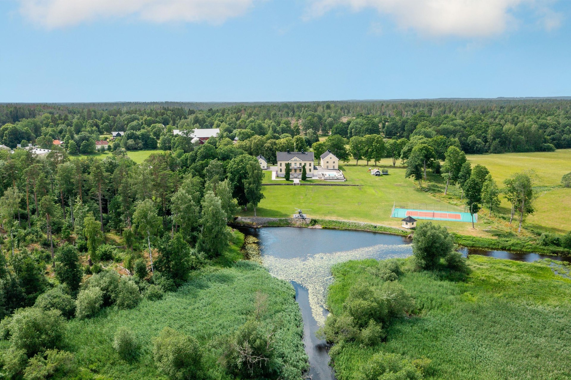 Flygbild över herrgården med damm och tennisbana