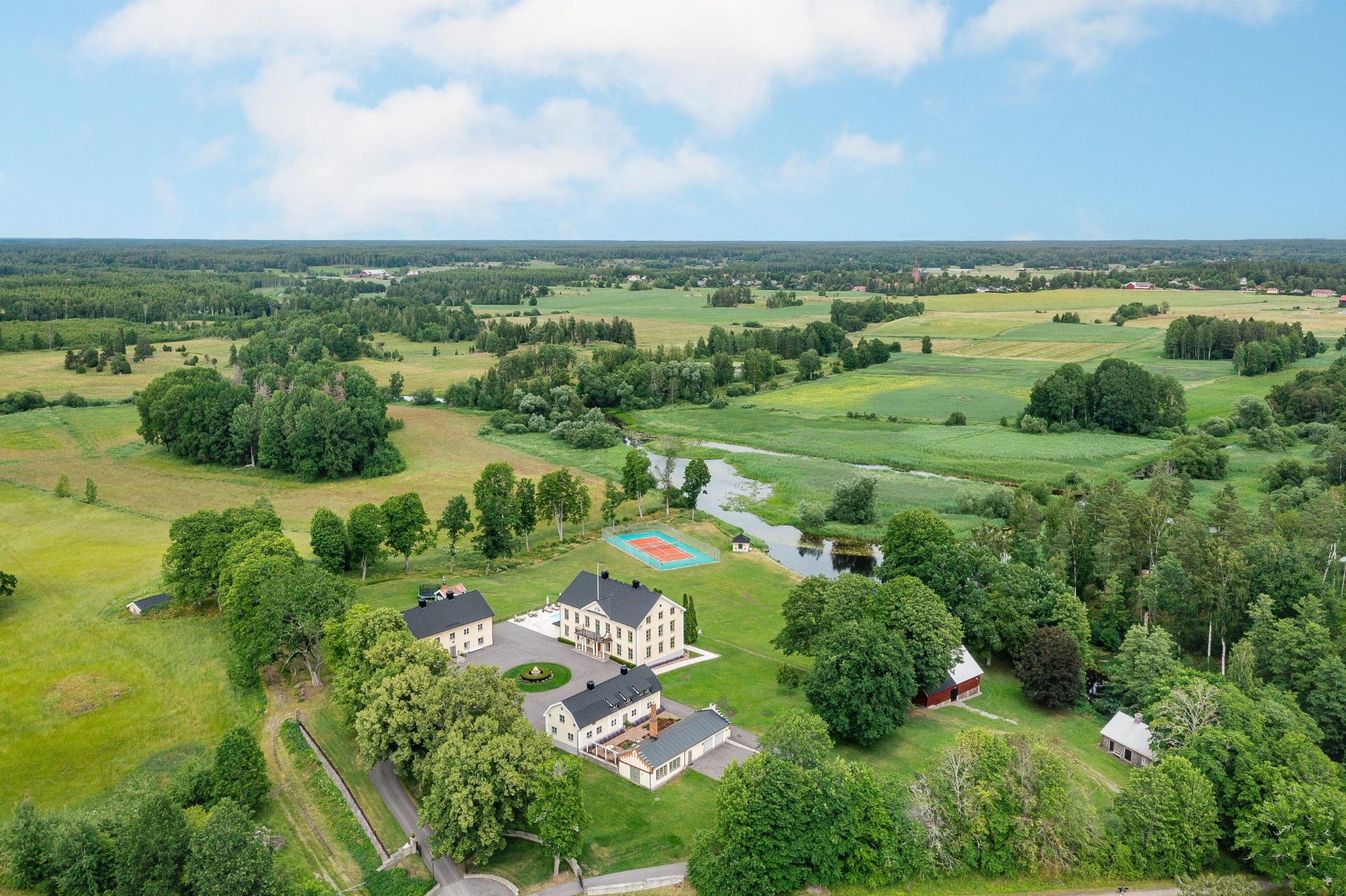 Flygbild över herrgården med vidsträckta ängar