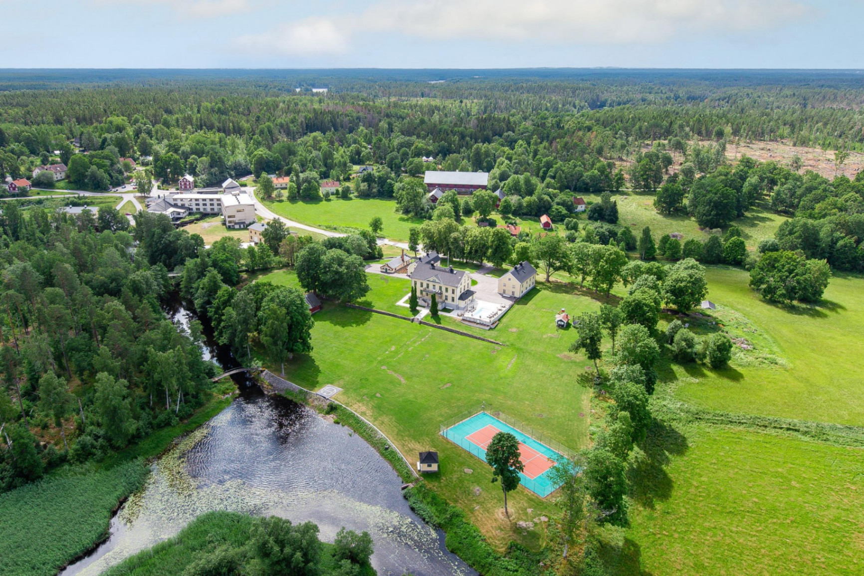 Flygbild över herrgården, tennisbana och vattendrag