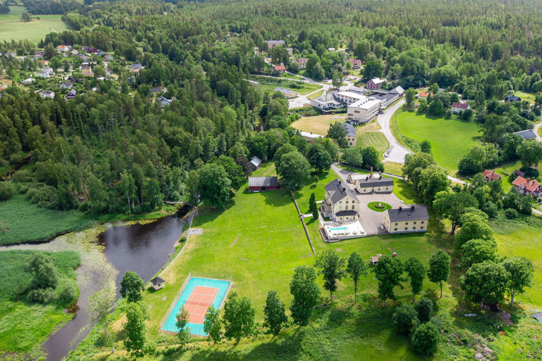 Flygbild över egendomen med byn i bakgrunden
