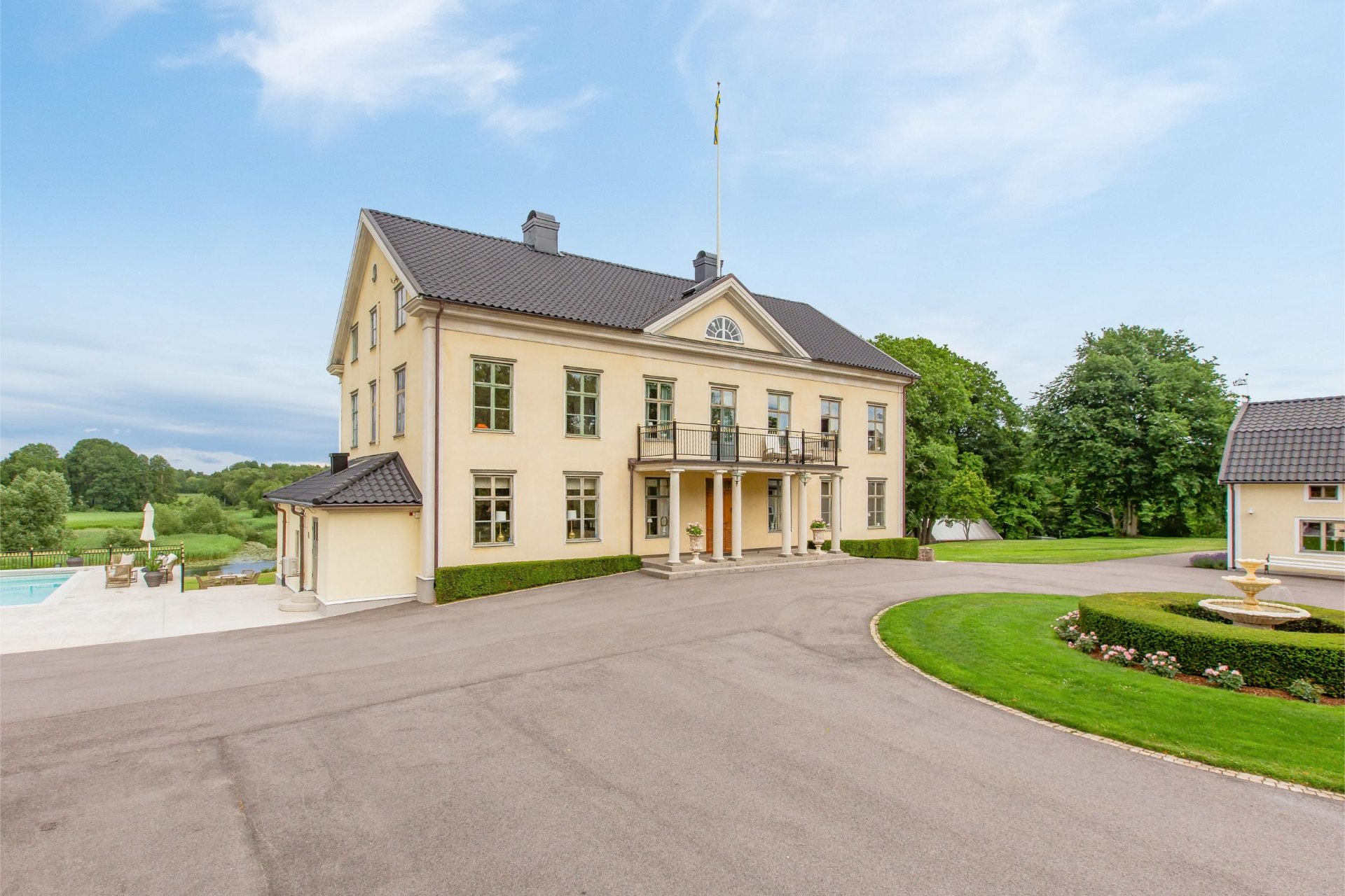 Herrgårdens framsida med pelare och balkong