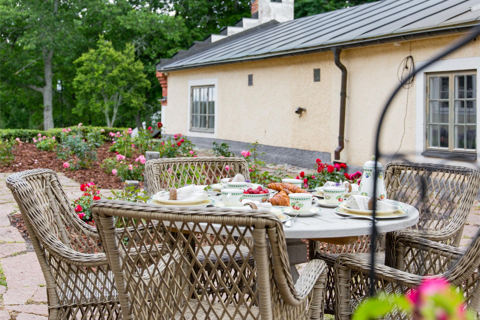 Dukad frukost utomhus bland rosor